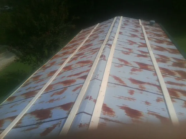Rusted metal roof panels with new wood purlins before replacement — Storm Damage Roof Repair in Pleasant Plain by Roofing Brothers
