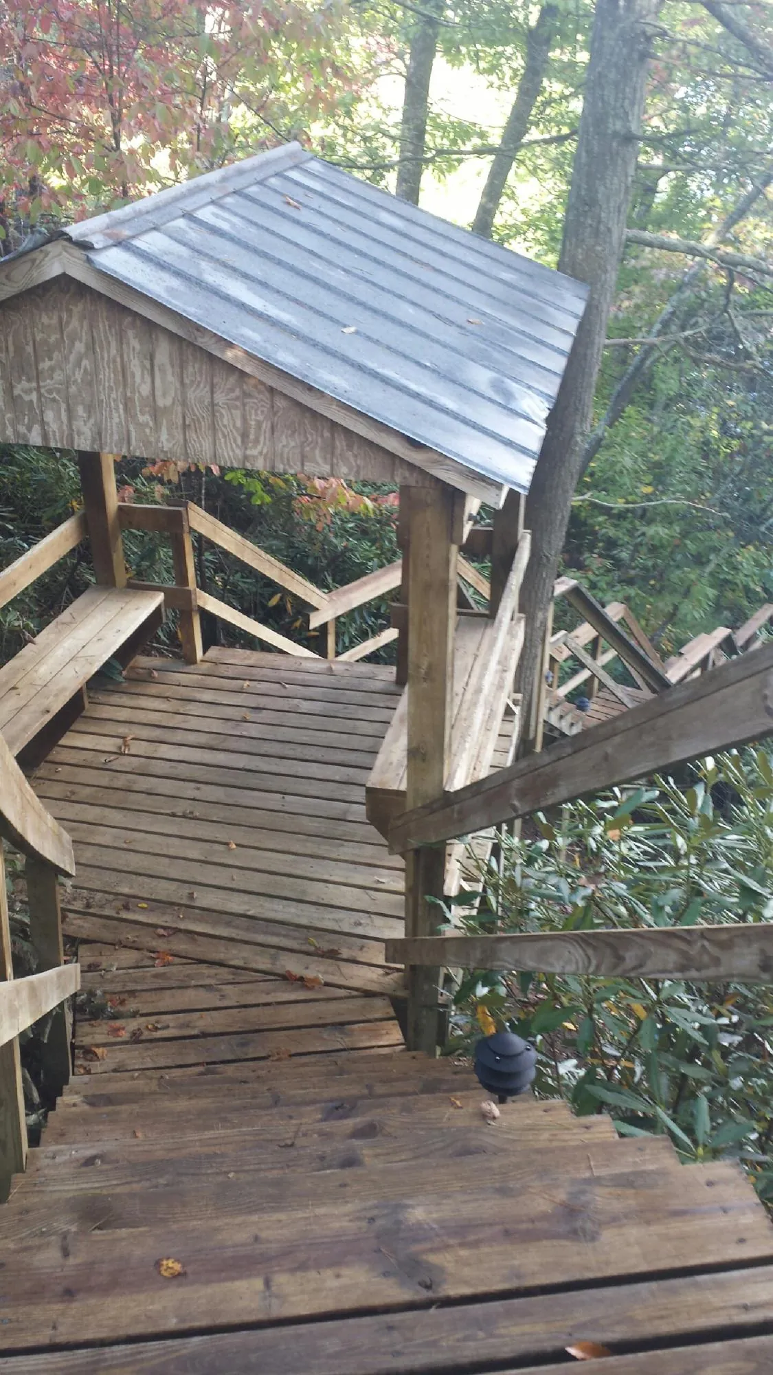 Metal roofed shelter over wooden steps on a wooded walkway — Skylight Repair & Installation work by our crew in Pleasant Plain