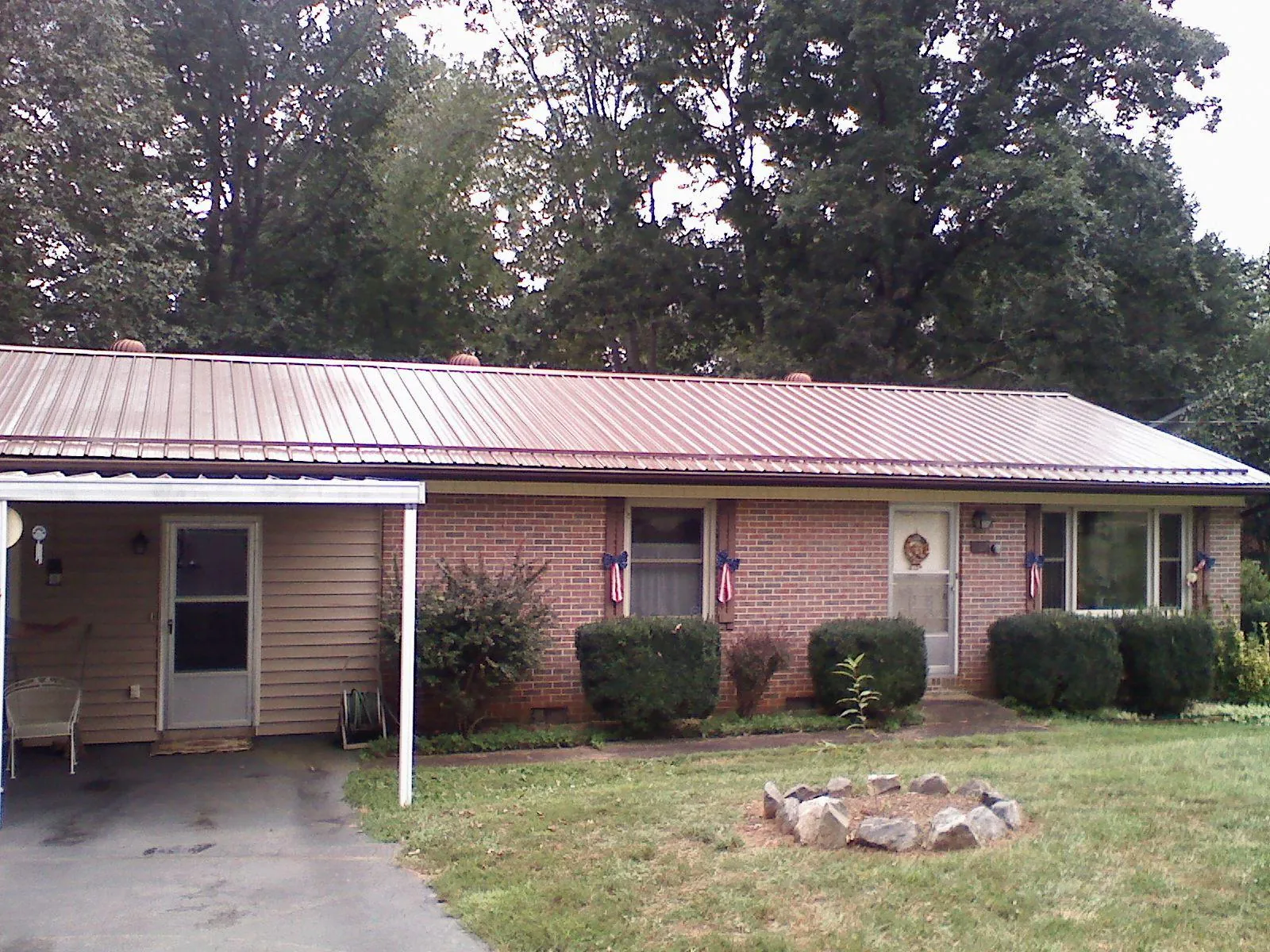Bronze metal roof and carport on a brick ranch home — Roof Repair work by our crew in Pleasant Plain